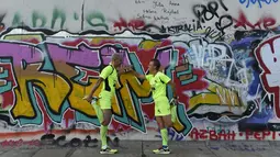 Sebuah lomba lari bertajuk "100 Meilen Berlin 2014" akan digelar di sepanjang Tembok Berlin. Tampak, Martina Schliep (kanan) dan Gaston Pruefer melakukan pemanasan sebelum latihan lari di sisi timur Tembok Berlin, (11/8/2014). (AFP PHOTO/Tobias Schwarz)