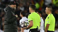 Pelatih Liverpool Jurgen Klopp (kiri) berbicara kepada ofisial pertandingan setelah pertandingan melawan Real Madrid pada pertandingan leg pertamababak 16 besar Liga Champions di stadion Anfield di Liverpool, Inggris, Rabu (22/2/2023). Kebobolan lima gol merupakan pertama kalinya dirasakan Liverpool di Liga Champions, terutama di kandang sendiri para partai kompetisi Eropa. (AFP/Paul Ellis)