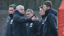 Pelatih Manchester United, Jose Mourinho berbincang dengan asissten pelatih selama sesi pelatihan tim di kompleks Pelatihan Carrington, Inggris (11/12). Saat ini MU berada di posisi kedua di grup tersebut dengan poin sepuluh. (AFP Photo/Lindsey Parnaby)