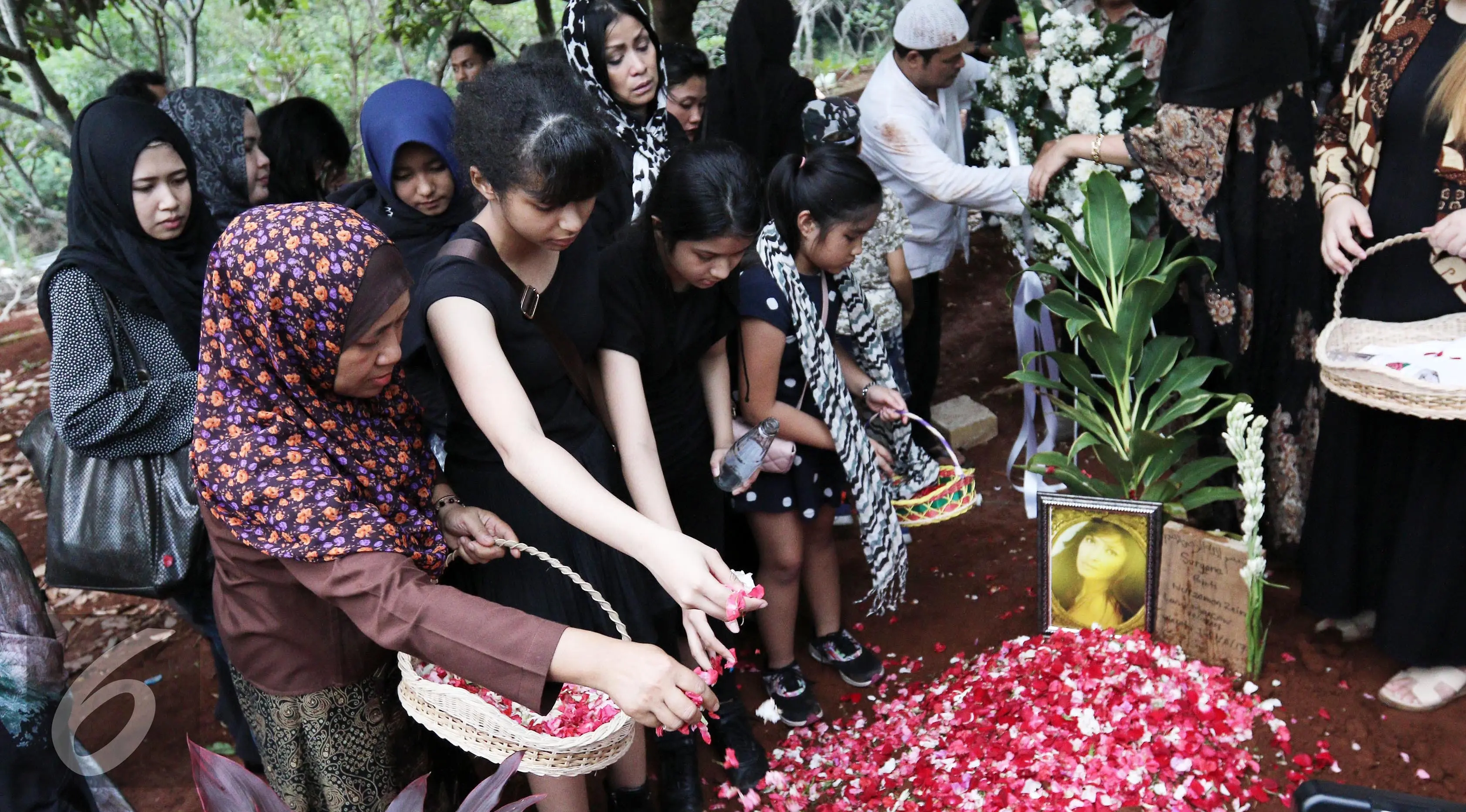 Suasana pemakaman Yana Zein. Terlihat dua putri Yana Zein, Aurelia dan Alika menaburi bunga di makam sang ibu. (Herman Zakharia/Liputan6.com)