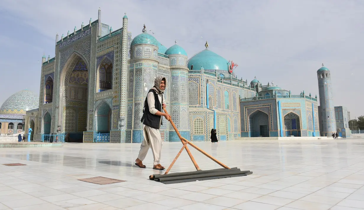Seorang pria membersihkan halaman depan Masjid Biru di Mazar-i-Sharif, ibu kota Provinsi Balkh, Afghanistan utara (11/7/2020). Setelah lima bulan ditutup akibat dampak pandemi COVID-19, Masjid Biru baru-baru ini telah dibuka kembali untuk umum. (Xinhua/Kawa Basharat)