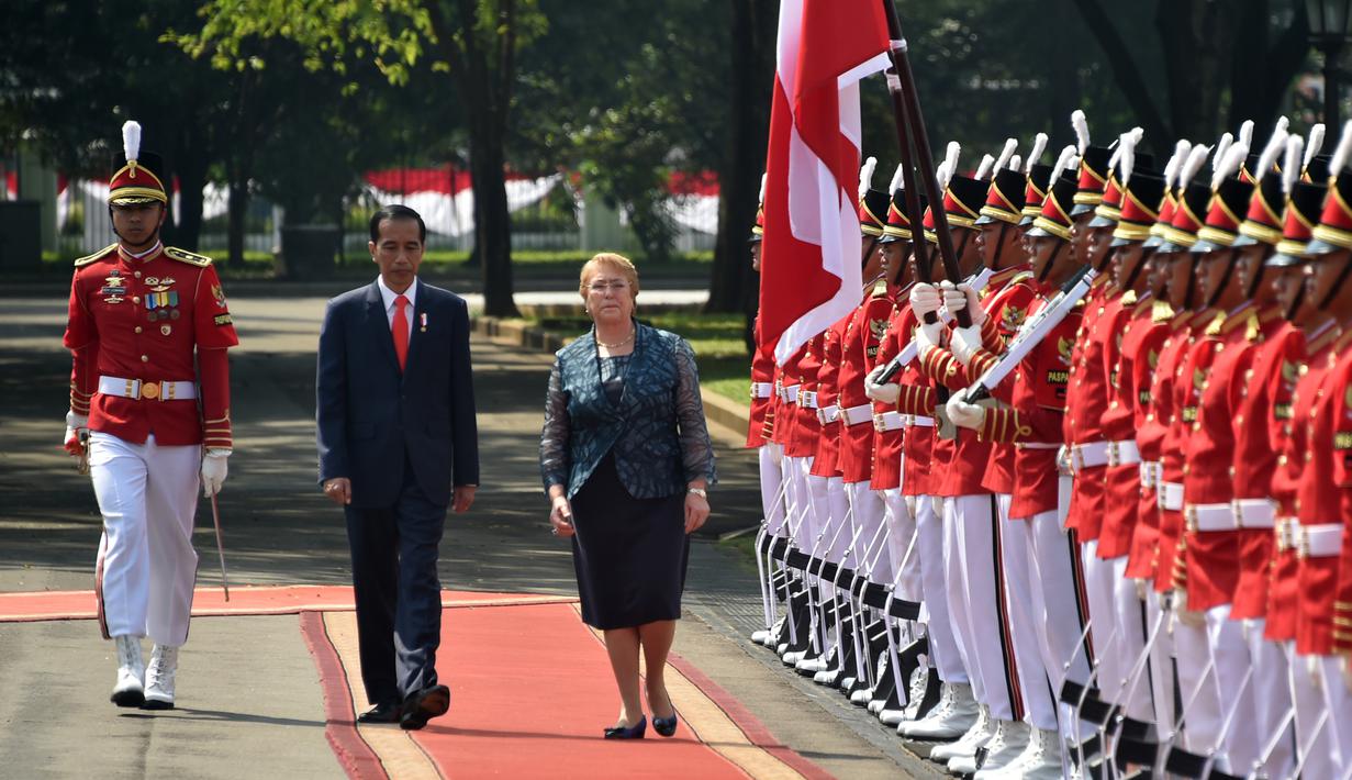 Presiden RI, Joko Widodo (Jokowi) mendampingi Presiden Presiden Republik Chile, Michelle Bachelet  Jeria memeriksa pasukan kehormatan saat upacara penyambutan kenegaraan di Istana Kepresidenan, Jakarta, Jumat (12/5). (Bay ISMOYO/AFP)