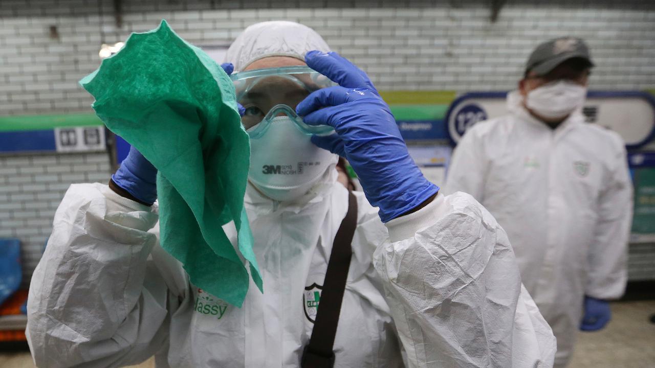 Petugas medis menyesuaikan kacamatanya saat akan menyemprotkan cairan disinfektan sebagai tindakan pencegahan virus corona (COVID-19) di Seoul, Korea Selatan, Jumat (21/2/2020). Jumlah pasien virus corona di Korea Selatan naik 293 kasus dari pengumuman sebelumnya.