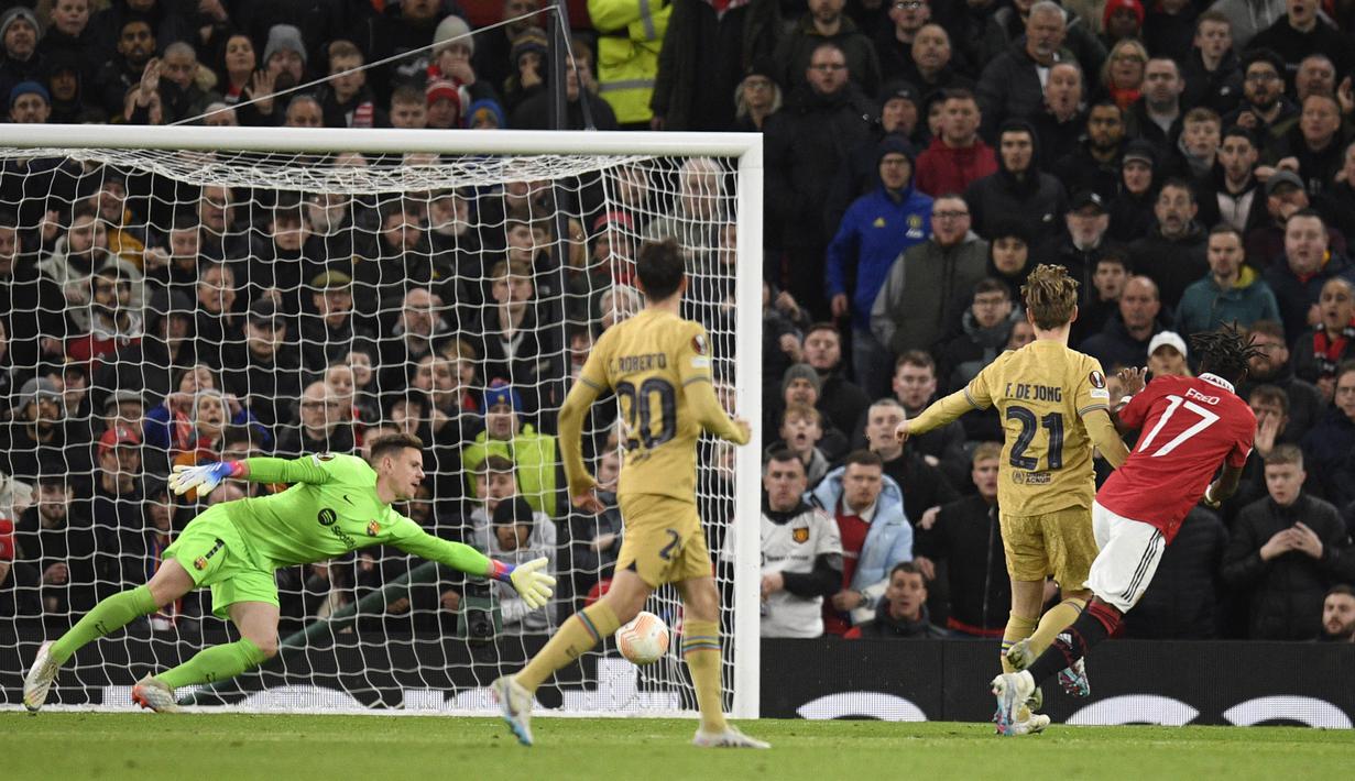 Pemain Manchester United, Fred (kanan) menendang bola ke gawang Barcelona yang membuahkan gol dalam pertandingan leg kedua play-off babak gugur Liga Europa 2022/2023 yang berlangsung di Old Trafford, Jumat (24/2/2023) WIB. (AFP/Oli Scarff)