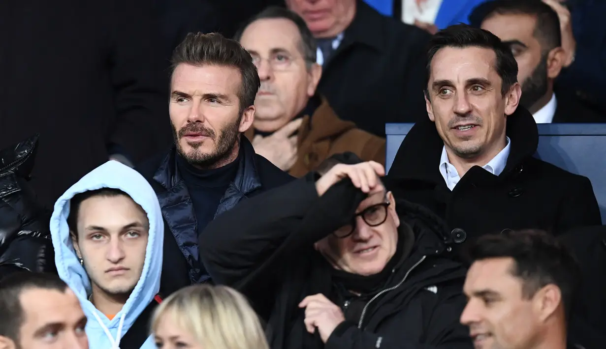 Mantan bintang sepak bola David Beckham (kiri) dan Gary Neville menonton pertandingan Liga Champions antara PSG dan Real Madrid di stadion Parc des Princes di Paris (6/3). (AFP Photo/Franck Fife)