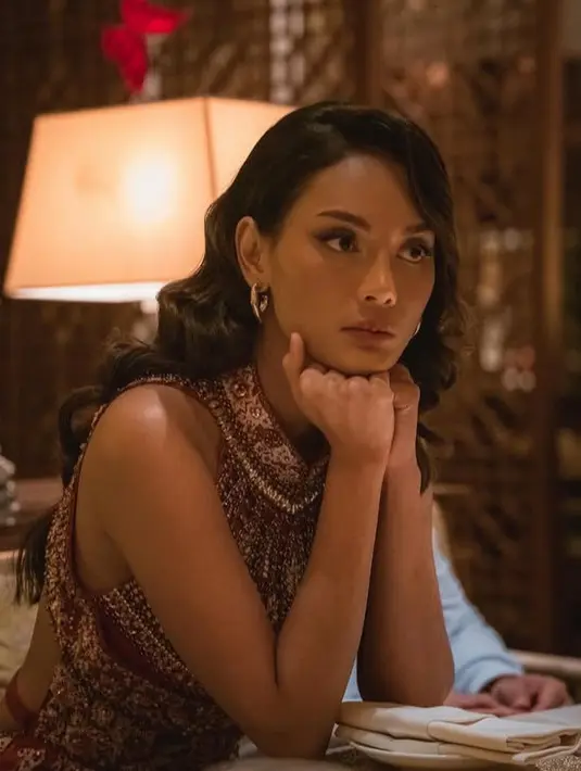 Erika Carlina tampil mewah mengenakan dress cheongsam merah dengan aksen beads silver. Dress tersebut memiliki kerah tinggi dan backless. [@eri.carl]