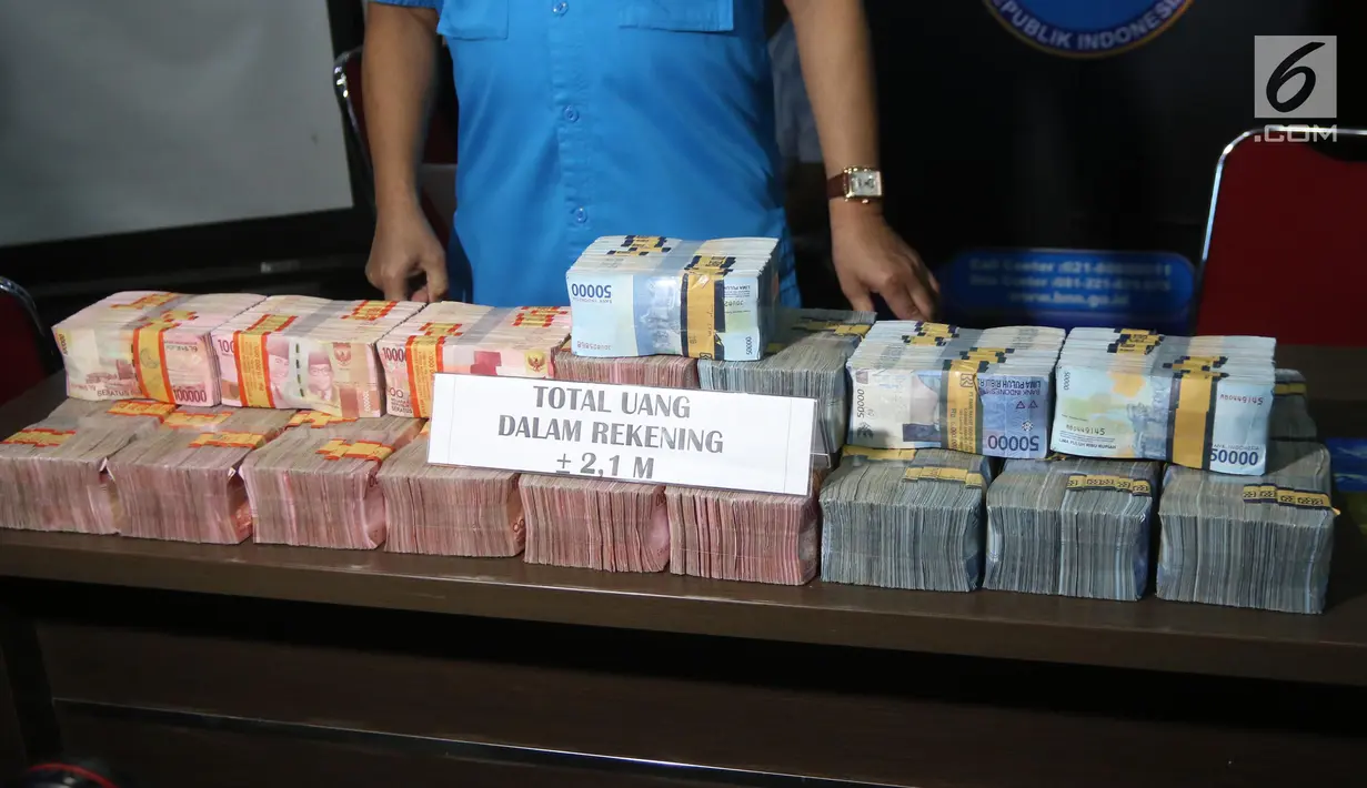 Petugas BNN menunjukkan barang bukti uang hasil tindak pidana pencucian uang (TPPU) di Kantor BNN, Jakarta, Selasa (17/7). Petugas mengamankan seorang tersangka dengan total aset Rp 3,9 miliar. (Liputan6.com/Arya Manggala)