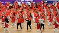 Menko PMK, Puan Maharani (tengah jaket hitam) bersama sejumlah atlet, pelatih dan official menari lagu tema Asian Games 2018 usai upacara pengukuhan di Istora Senayan, Jakarta, Minggu (5/8). (Liputan6.com/Helmi Fithriansyah)