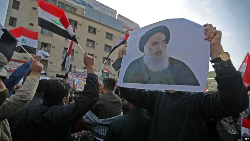 Rakyat Irak membawa foto ulama Syiah top negara itu, Ayatollah Ali al-Sistani, ketika mereka berdemonstrasi di ibu kota Tahrir Square, Baghdad, 5 Desember 2019.