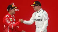 Pebalap Mercedes, Valtteri Bottas, dan driver Ferrari, Sebastian Vettel, berjabat tangan setelah balapan F1 GP Austria di Sirkuit Red Bull Ring, Minggu (9/7/2017). (AP/Darko Bandic)