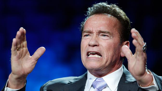 Aktor AS, Arnold Schwarzenegger berbicara pada forum KTT One Planet Summit di Paris, Selasa (12/12). Mantan Gubernur California itu mencuri perhatian dengan dua cincin di jari yang salah satunya bermotif tengkorak warna perak. (AP Photo/Christophe Ena)