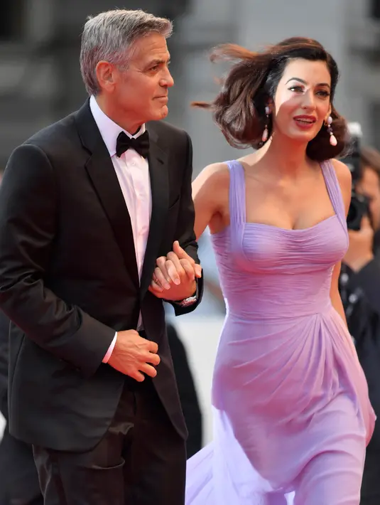 Pasangan selebritis, George Clooney dan Amal Clooney setibanya di karpet merah Venice Film Festival ke-74, Italia, 2 September 2017. Di kesempatan itu, George pun tak kalah menawan dengan tuksedo keluaran Armani. (TIZIANA FABI / AFP)