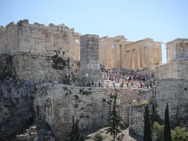 Wisatawan meninggalkan kuil kuno Parthenon di bukit Acropolis di Athena, Yunani pada Rabu (17/7/2024). (Aris Oikonomou / AFP)