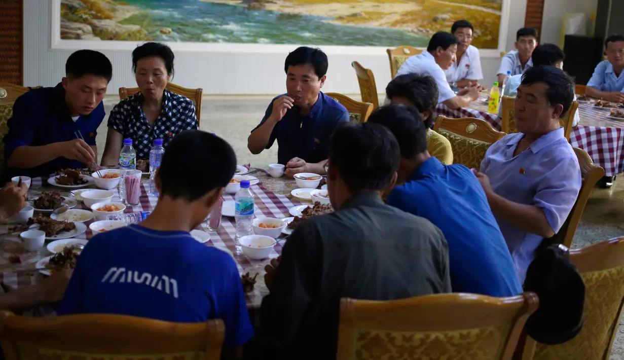 Pengunjung menikmati makan siang di restoran khusus anjing Pyongyang House of Sweet Meat, Rabu (25/7). Suhu di Korea Utara pada tahun ini termasuk yang tertinggi dari yang pernah tercatat dengan kisaran hampir 40 derajat Celsius. (AP/Dita Alangkara)