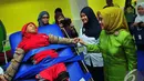 Istri Wakil Presiden RI Mufidah Jusuf Kalla berbincang dengan salah seorang anak saat menghadiri acara 60 tahun Yayasan Pembinaan Anak Cacat (YPAC) Jakarta, Rabu (5/11/2014) (Liputan6.com/Johan Tallo)