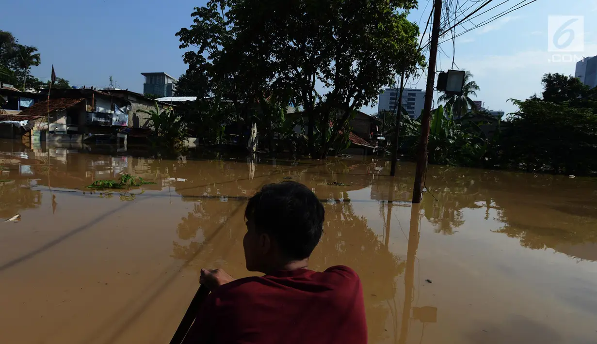 Warga melintasi banjir di kampung Arus Cawang, Jakarta Timur, Jumat (26/4). Ketinggan banjir kurang lebih satu meter terjadi akibat luapan kali Ciliwung dan intensitas curah hujan di kawasan Bogor Jawa Barat sangat tinggi sehingga aktivitas warga terhambat. (merdeka.com/Imam Buhori)