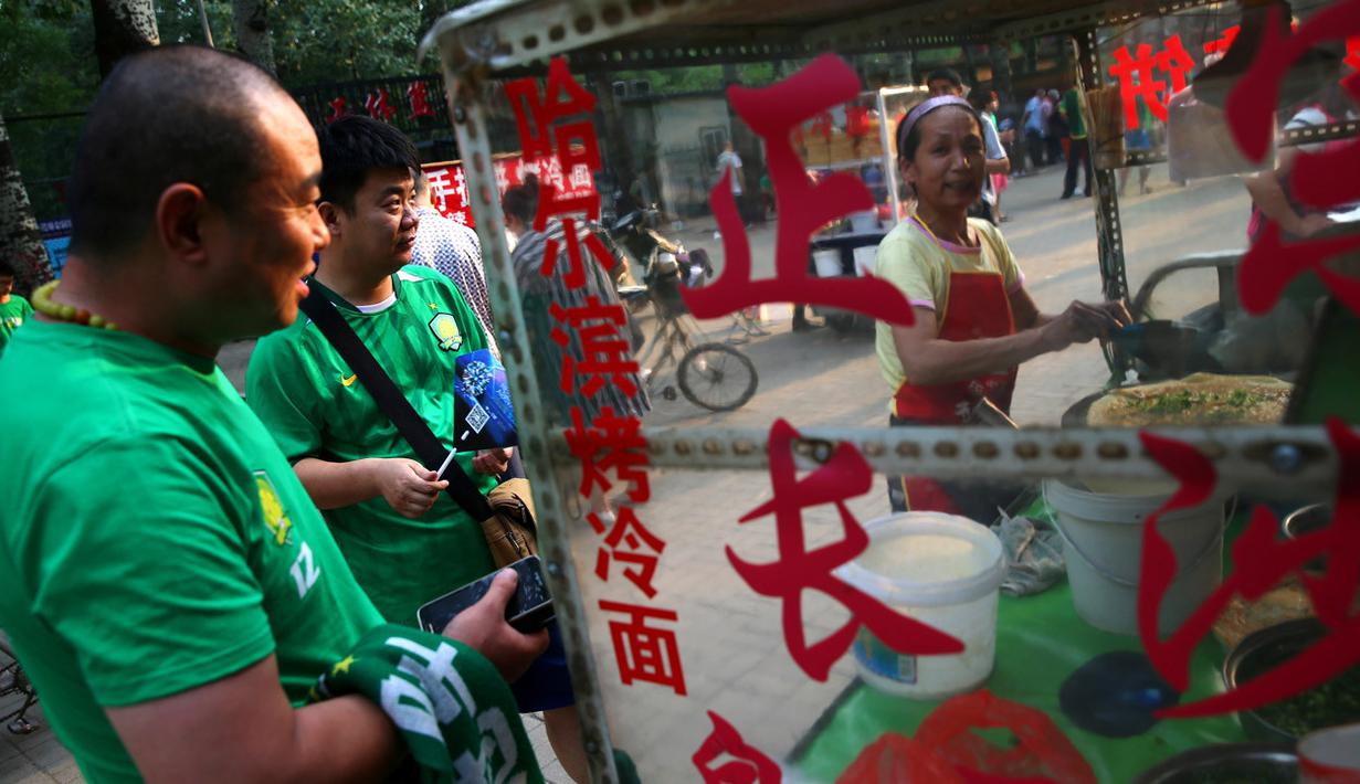 Suporter klub Beijing Guoan FC menikmati jajanan tradisional sebelum kompetisi Liga Super China. (EPA/Wu Hong)
