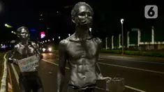 Manusia silver saat menghibur pengendara bermotor di perempatan kawasan Senayan, Jakarta, Sabtu (9/5/2020). Di tengah pandemi Covid-19 para manusia silver atau disebut "Patung Berjalan" itu tetap mengais rezeki untuk memenuhi kebutuhan sehari-hari (merdeka.com/Imam Buhori)