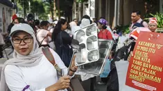 Seorang perempuan memukul peralatan dapur saat melakukan protes menuntut pemerintah meninjau kembali program Makan Bergizi Gratis (MBG), menurunkan harga Bahan Bakar Minyak (BBM), dan membuka lebih banyak lapangan kerja bagi perempuan, di Jakarta, Kamis 18 Juni 2026. (BAY ISMOYO/AFP)