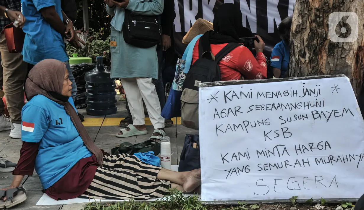 Warga gusuran Kampung Bayam saat menggelar aksi di depan Balai Kota DKI Jakarta, Kamis (1/12/2022). Dengan membawa terpal dan perabotan rumah tangga, puluhan korban gusuran Kampung Bayam mendatangi Balai Kota untuk menuntut PT Jakarta Propertindo (JakPro) segera menyerahkan kunci hunian Kampung Susun Bayam (KSB) serta memberikan harga sewa yang murah. (merdeka.com/Iqbal S Nugroho)