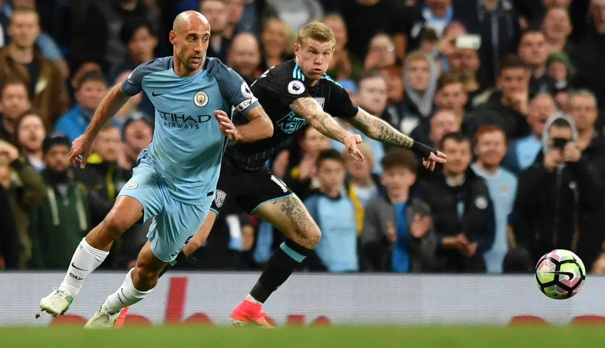Bek Manchester City, Pablo Zabaleta (kiri) berebut bola dengan gelandang West Bromwich Albion, James McClean saat bertanding pada pertandingan Liga Inggris di Stadion Etihad, Manchester,(16/5).City menang 3-1 atas West Brom. (AFP Photo/Anthony Devlin)