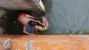 Dua orang anak bercanda ketika bermain dan berenang di anak Kali Ciliwung, Jakarta, Rabu (13/7). Bersihnya kali yang berada di Ibu Kota itu dimanfaatkan anak-anak sekitar untuk berenang sambil mengisi waktu libur sekolah. (Liputan6.com/Immanuel Antonius) 