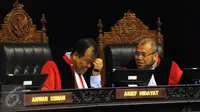 Hakim MK, Patrialis akbar (kanan) berbincang dengan Ketua MK, Arief Hidayat disela-sela sidang di Gedung Mahkamah Konstitusi, Jakarta, Selasa (22/9/2015).  (Liputan6.com/Helmi Fithriansyah)