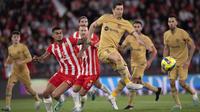 Pemain Barcelona, Robert Lewandowski (tengah) berusaha mencetak gol ke gawang Almeria pada laga lanjutan Liga Spanyol 2022/2023 yang berlangsung di Power House Stadium, Senin (27/02/2023) dini hari WIB. (AFP/Jorge Guerrero)