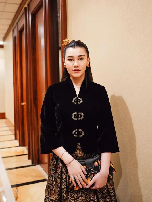 Rok dengan panjang asimetris ini memiliki corak batik berwarna emas di atas warna dasarnya yang hitam. [Foto: Instagram/aaliyah.massaid]