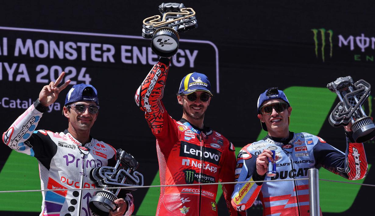 Pebalap Ducati Lenovo, Francesco Bagnaia (tengah) bersama Jorge Martin (kiri) dan Marc Marquez merayakan kemenangan usai balapan MotoGP Catalunya 2024, Minggu (26/4/2024). (LLUIS GENE/AFP)