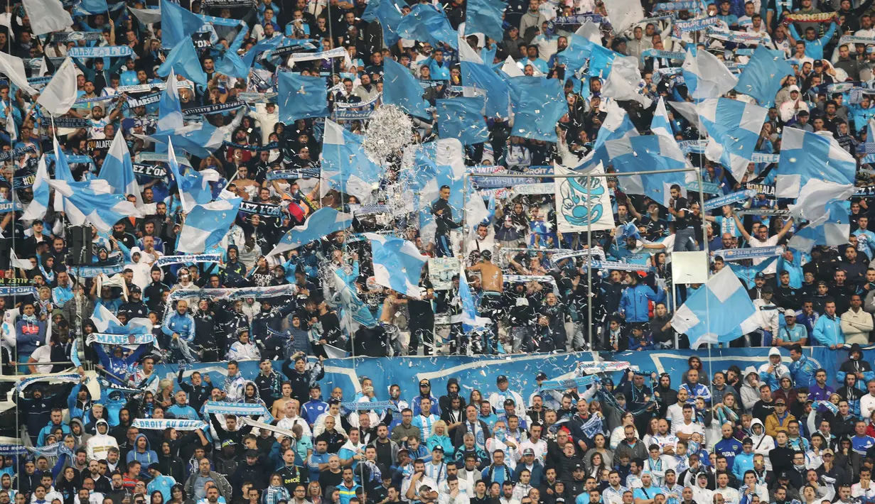 Aksi ribuan suporter Marseille memberikan dukungan kepada timnya saat melawan PSG  pada lanjutan Ligue 1 di  Velodrome Stadium, Marseille, (22/10/2017). PSG bermain imbang 2-2 melawan Marseille. (AFP/Valery Hache)