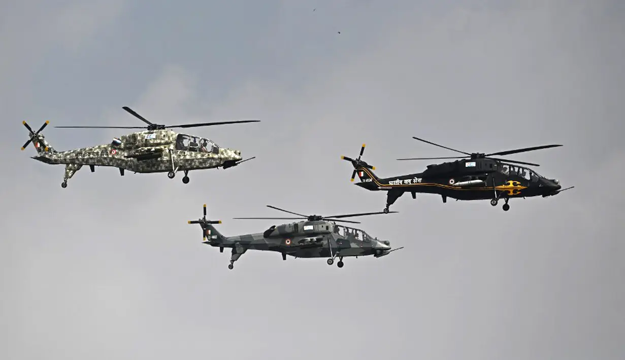 Helikopter Angkatan Udara India tampil pada hari pertama Aero India 2021 Airshow di Stasiun Angkatan Udara Yelahanka, Bangalore, India, Rabu (3/2/2021). Aero India 2021 disebut-sebut sebagai pertunjukan aero dan pertahanan hybrid pertama di dunia. (Jewel SAMAD/AFP)