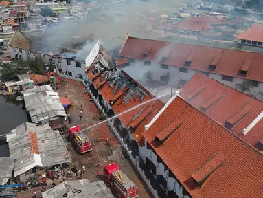 Petugas pemadam kebakaran memadamkan sisa api yang membakar Museum Bahari di Penjaringan, Jakarta Utara, Selasa (16/1). Gedung Museum Bahari terbakar saat gedung tengah kosong  sekitar pukul 08.45 WIB. (Liputan6.com/Arya Manggala)