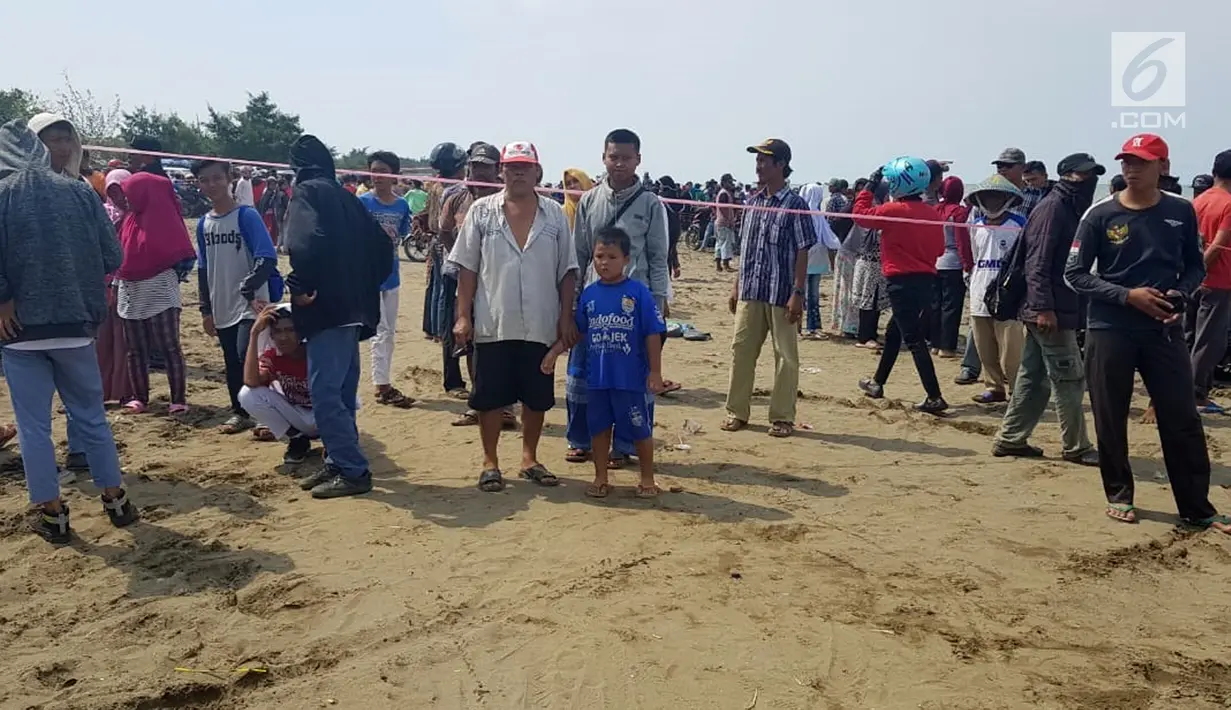 Warga berkerumun menantikan evakuasi pesawat Lion Air JT 610 di Pantai Pakis Jaya, Karawang, Jawa Barat, Senin (29/10). Pesawat Lion Air JT 610 dilaporkan hilang sekitar pukul 06.00 WIB. (Liputan6.com/Herman Zakharia)
