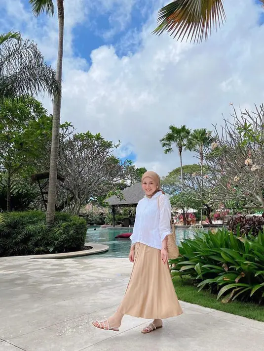 9. Nuansa earth-tone memang paling cocok dengan suasana Bali, padukan kemeja putih dengan pleats skirt warna krem dan hijab warna senada seperti potret Kesha Ratuliu satu ini.  (Instagram/kesharatuliu05).