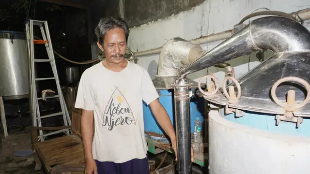 Oki sedang menunjukkan mesin penyulingan minyak atsiri rancangannya.