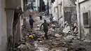 Warga Palestina berjalan setelah penyerbuan militer Israel ke kamp pengungsi Nur Shams di Tepi Barat, Rabu 27 Desember 2023. (AP Photo/Majdi Mohammed)