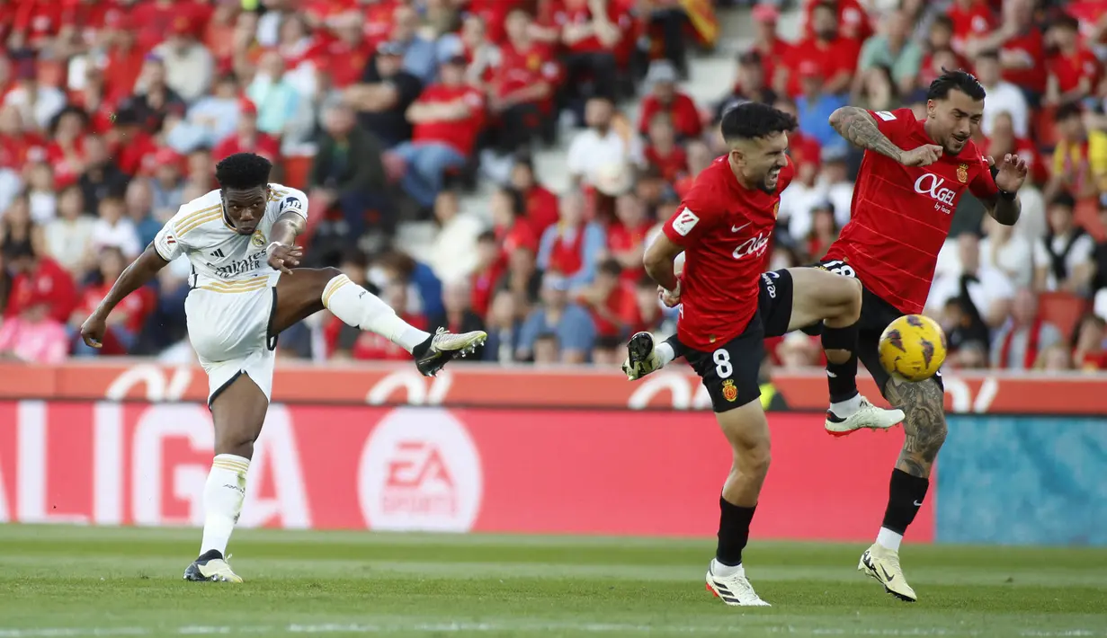 Pemain Real Madrid, Aurelien Tchouameni, melepaskan tendangan keras yang sukses bersarang di gawang Real Mallorca pada laga Liga Spanyol di Stadion Son Moix, Sabtu (13/4/2024). Los Blancos menang dengan skor 1-0. (AFP/Jaime Reina)