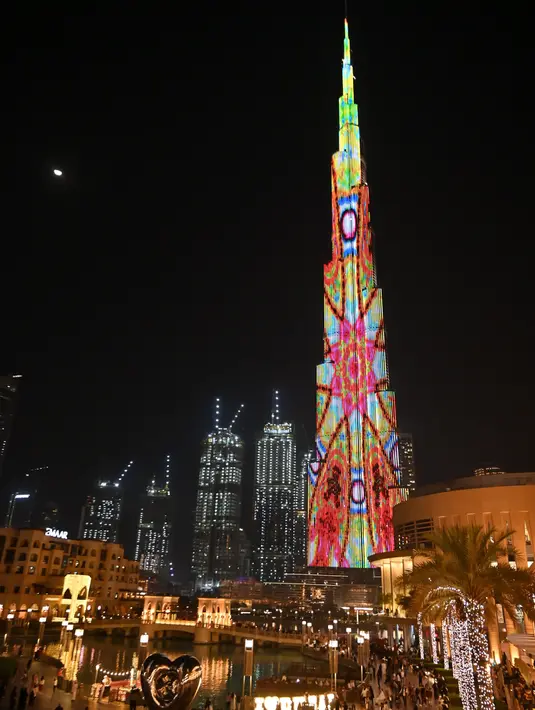 Foto yang diambil pada 4 Januari 2020 memperlihatkan pertunjukan cahaya menyinari Burj Khalifa, bangunan tertinggi dunia, di Dubai. Burj Khalifa yang resmi dibuka pada 4 Januari 2010 itu merayakan hari jadinya yang ke-10 dengan pertunjukan lampu LED khusus. (Giuseppe CACACE / AFP)