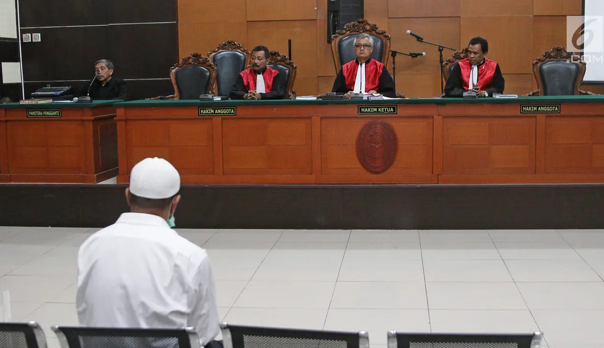 Terdakwa kasus penembakan dr Letty Sultri, dr Helmi mendengarkan dakwaan yang dibacakan oleh JPU di PN Jakarta Timur, Kamis (29/3). Helmi didakwa telah menembak istrinya hingga tewas pada 9 November 2017. (Liputan6.com/Herman Zakharia)