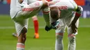Ekspresi pemain Spanyol, Isco Alarcon saat sepatunya dicium oleh Sergio Ramos usai ia mencetak gol saat pertandingan persahabatan melawan Argentina di stadion Wanda Metropolitano di Madrid (27/3). Isco berhasil mencetak tiga gol. (AP Photo / Paul White)