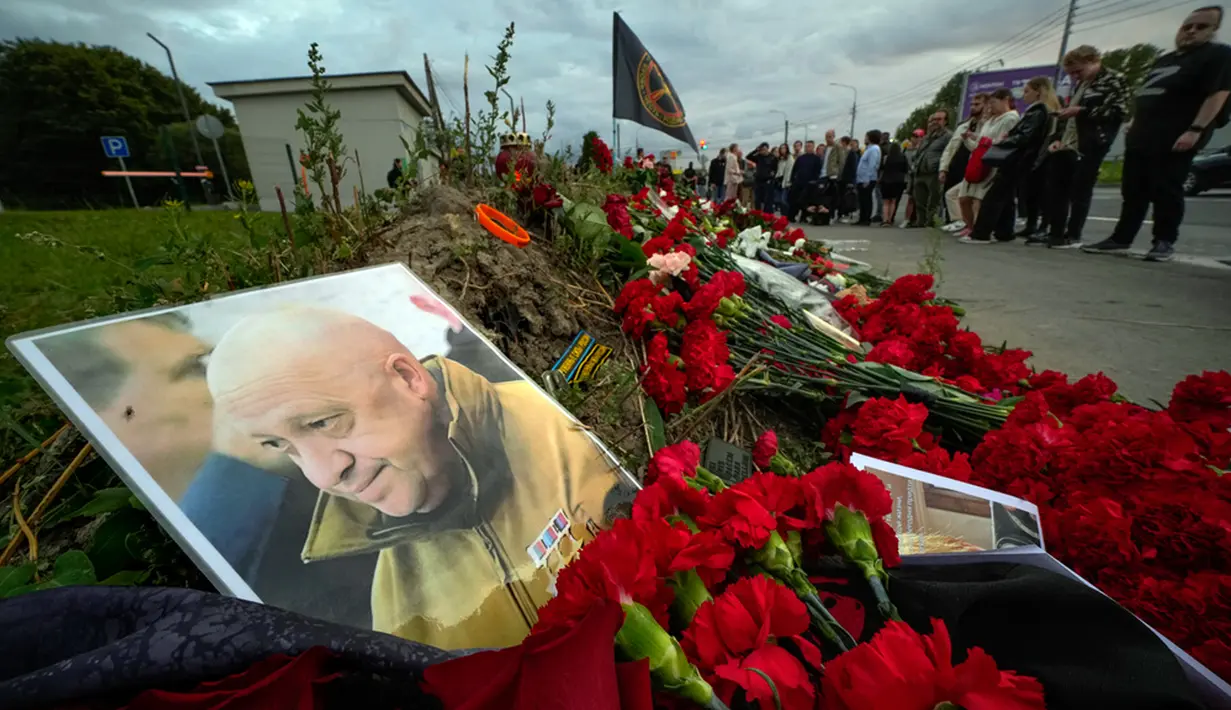 Potret pemilik perusahaan militer swasta Wagner Group Yevgeny Prigozhin diletakkan saat peringatan informal di sebelah bekas 'PMC Wagner Center' di St. Petersburg, Rusia, Kamis (24/8/2023). Badan penerbangan sipil Rusia mengatakan pemimpin tentara bayaran Yevgeny Prigozhin berada di dalam pesawat yang jatuh di utara Moskow. (AP Photo/Dmitri Lovetsky)