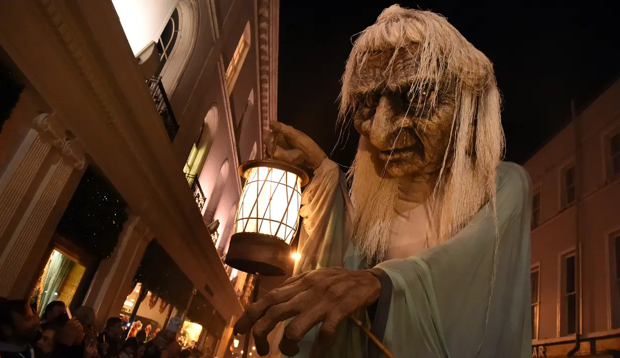 Boneka nenek sihir raksasa berjalan dikerumunan warga saat menghadiri Parade Halloween di Irlandia (30/10). Parade yang juga dikenal dengan Savage Grace Galway ini menghadirkan nenek sihir, serigala, dan burung hantu. (REUTERS/Clodagh Kilcoyne)