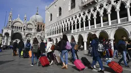 Turis berjalan di sepanjang Doge's Palace menuju Basilika Santo Markus di Venesia (4/11/2019). Kota ini memiliki luas wilayah 412 km² dan populasi 271.663 jiwa (2003). (AFP Photo/Miguel Medina)