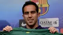 Claudio Bravo memamerkan seragam klub barunya, Barcelona, di Stadion Camp Nou, (7/7/2014). Bravo diboyong Barcelona dari Sociedad dengan nilai kontrak sebesar sembilan juta Euro. (AFP PHOTO/Josep Lago)