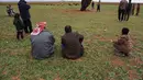 Keberadaan proyektil tersebut menarik perhatian penduduk lokal, termasuk anak-anak dan penggembala muda, untuk mendekati dan melihat dari dekat. Tampak dalam foto, warga setempat melihat proyektil rudal Iran yang belum meledak di lapangan terbuka di pinggiran Qamishli, Suriah timur, Rabu 4 Maret 2026. (AP Photo/Baderkhan Ahmad)
