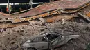 Sebuah mobil ringsek tertimpa reruntuhan bangunan yang ambruk akibat gempa 7,1 SR di Jojutla, negara bagian Morelos, Meksiko, Selasa (19/9). Ini merupakan gempa terkuat kedua yang mengguncang Meksiko dalam bulan ini. (AP Photo/Carlos Rodriguez)