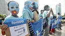 Warga mengenakan topeng bendera Turkestan Timur dan membentangkan poster saat menggelar Aksi Save Uighur selama Hari Bebas Kendaraan Bermotor (HBKB) atau Car Free Day (CFD), Jakarta, Minggu (22/12/2019). (merdeka.com/Iqbal S. Nugroho)
