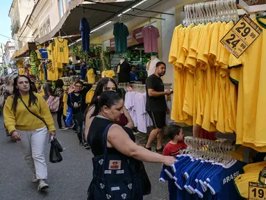 Seorang penggemar sepak bola Brasil melihat-lihat jersey tim nasional sepak bola yang dipajang di pasar Saara, Rio de Janeiro, Brasil, pada Selasa 9 Juni 2026, menjelang turnamen Piala Dunia FIFA 2026. (Nelson ALMEIDA/AFP)