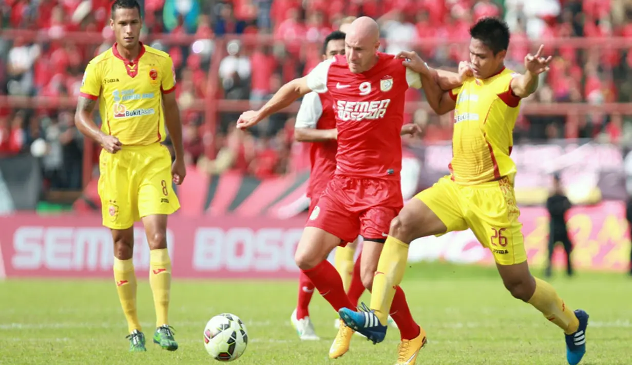 Striker impor PSM Nemanja Vucicevic berduel dengan bek Sriwijaya FC Fachrudin Aryanto. (Liga Indonesia)